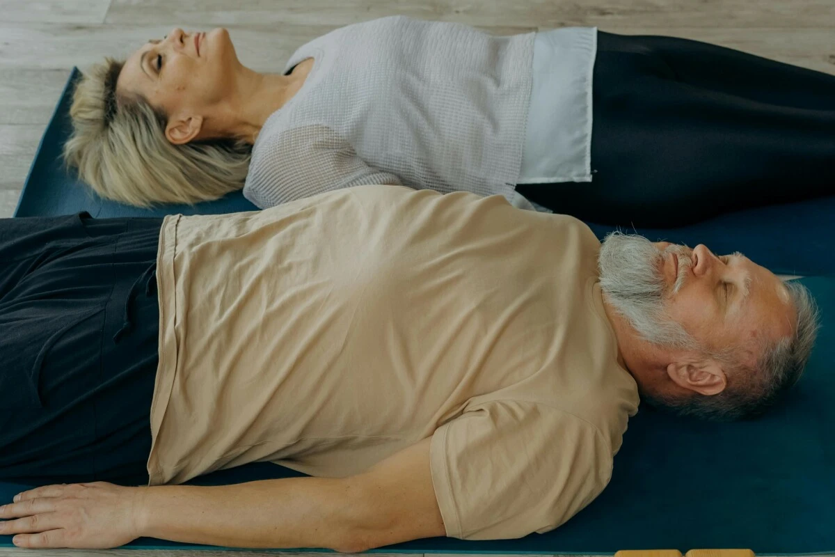 Mature couple lay on a mat on the floor