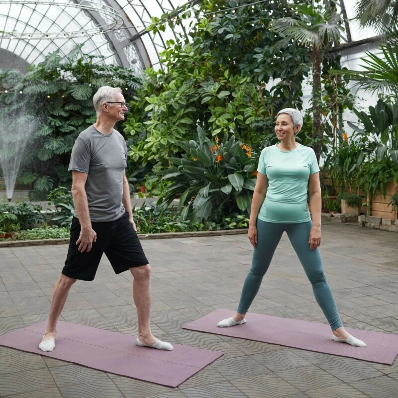 Mature man and woman ex on mats in a palm house