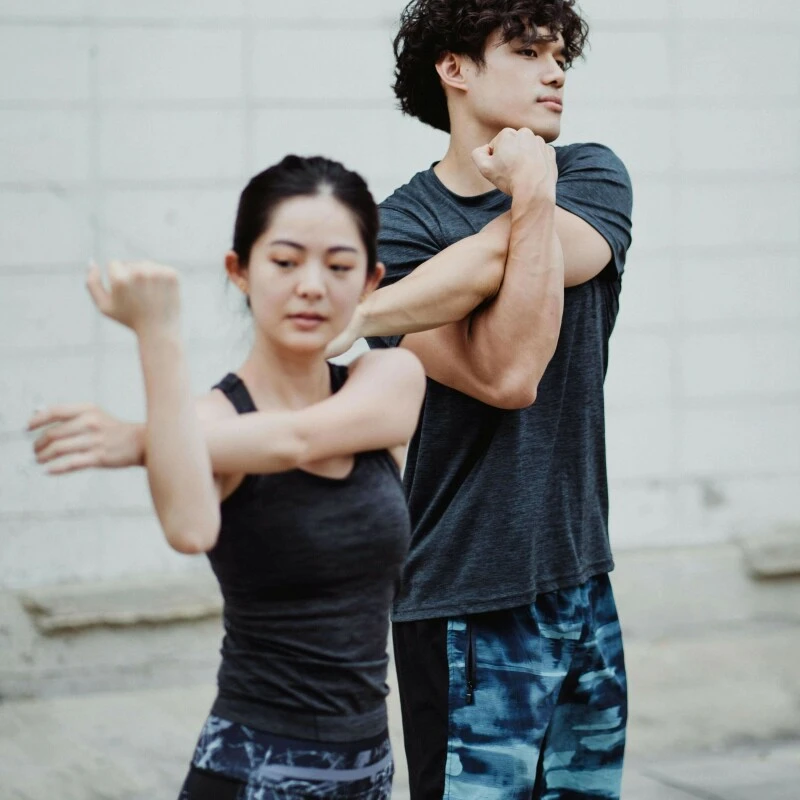 Young man and woman exercising in gym outfits