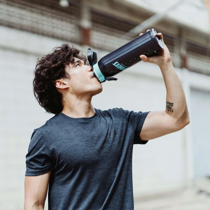 Young man in a t-shirt drinking from a drinks bottle