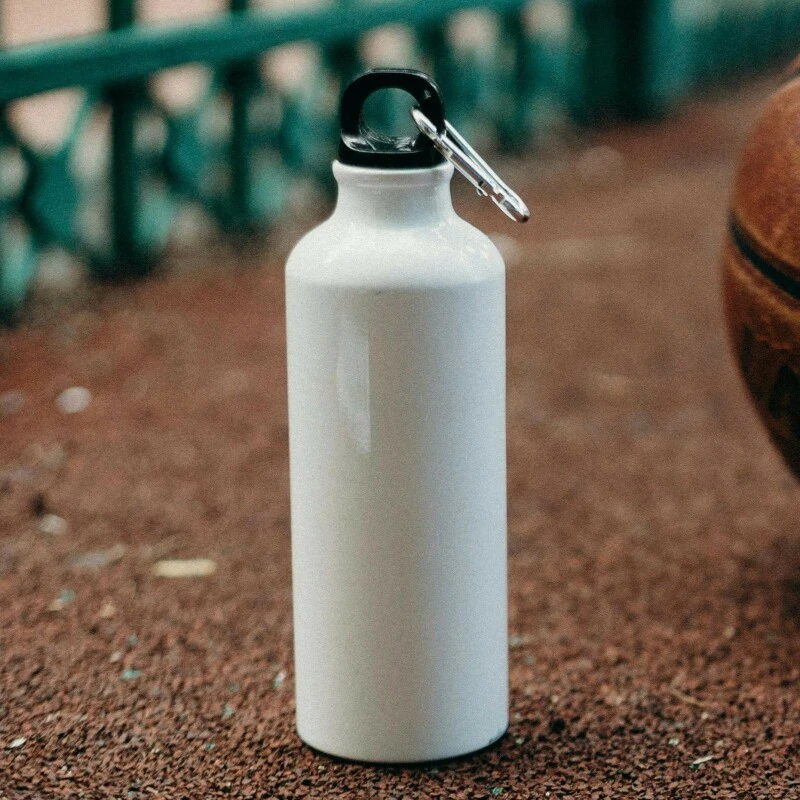 A white metal drinks bottle and basketball
